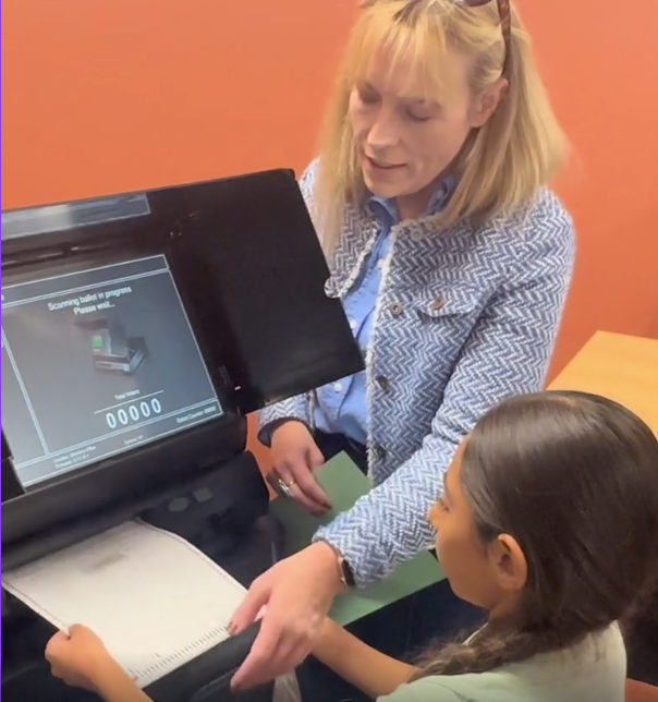 Santa Fe County Clerk Katharine E. Clark showing a child how to vote